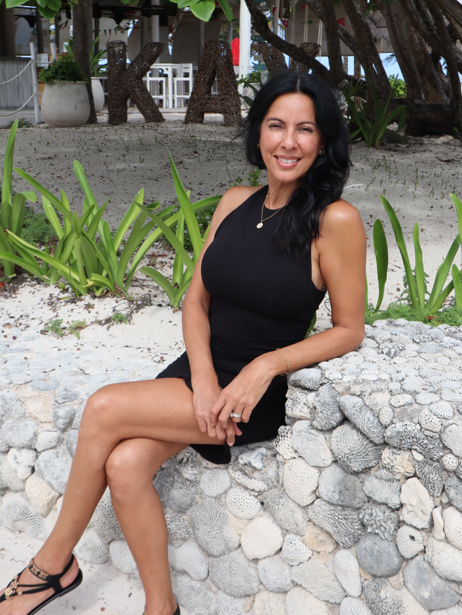 Resma Byrne, Ed.D., founder of Learning Crossroads, seated in a tropical garden